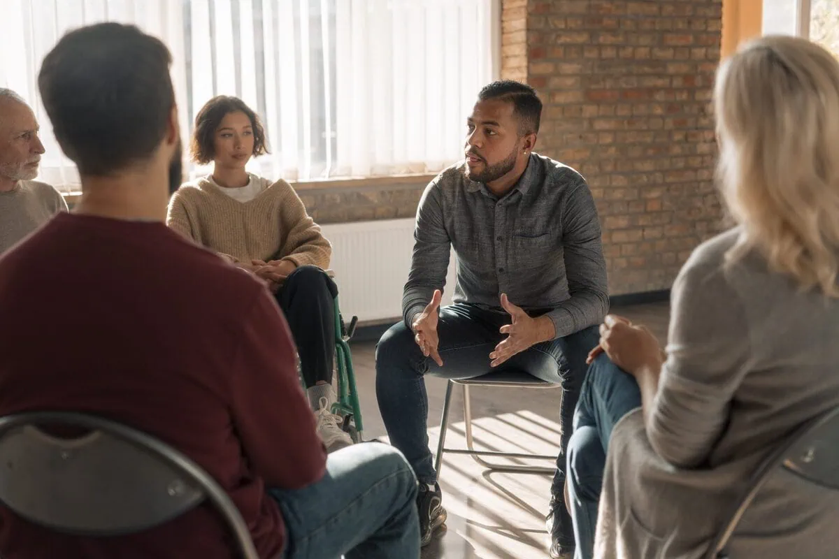 People sitting in a circle during a support group meeting