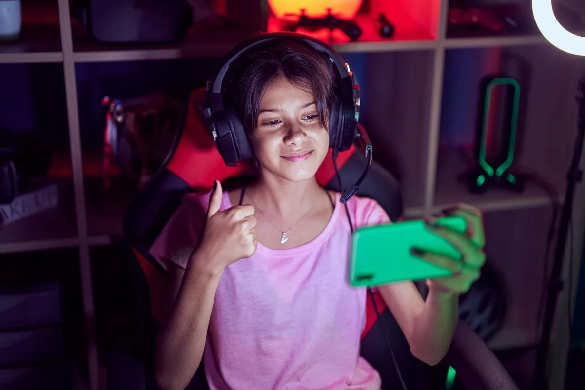 A smiling person giving a thumbs-up during an online session