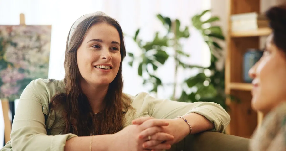 A mother and daughter talking together on a sofa